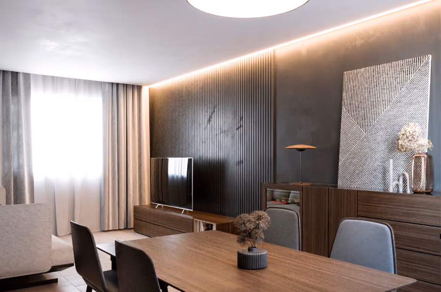 Salón de la vivienda Falcó, con iluminación puntual y mobiliario de firma.